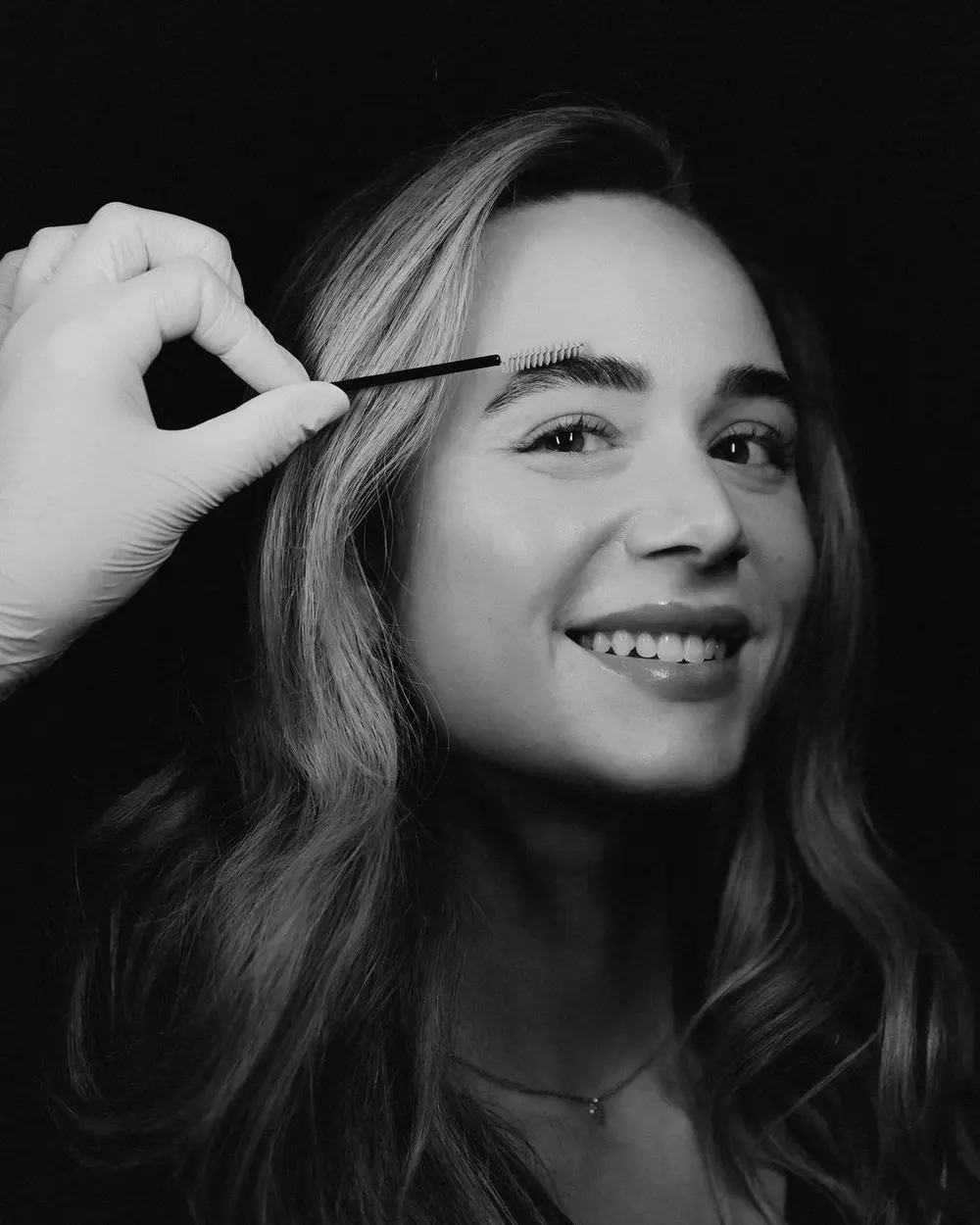 Brow shaping in progress, black and white portrait