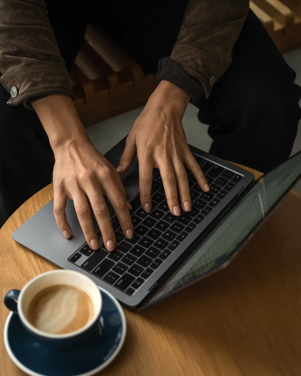Nude manicure at a laptop over coffee