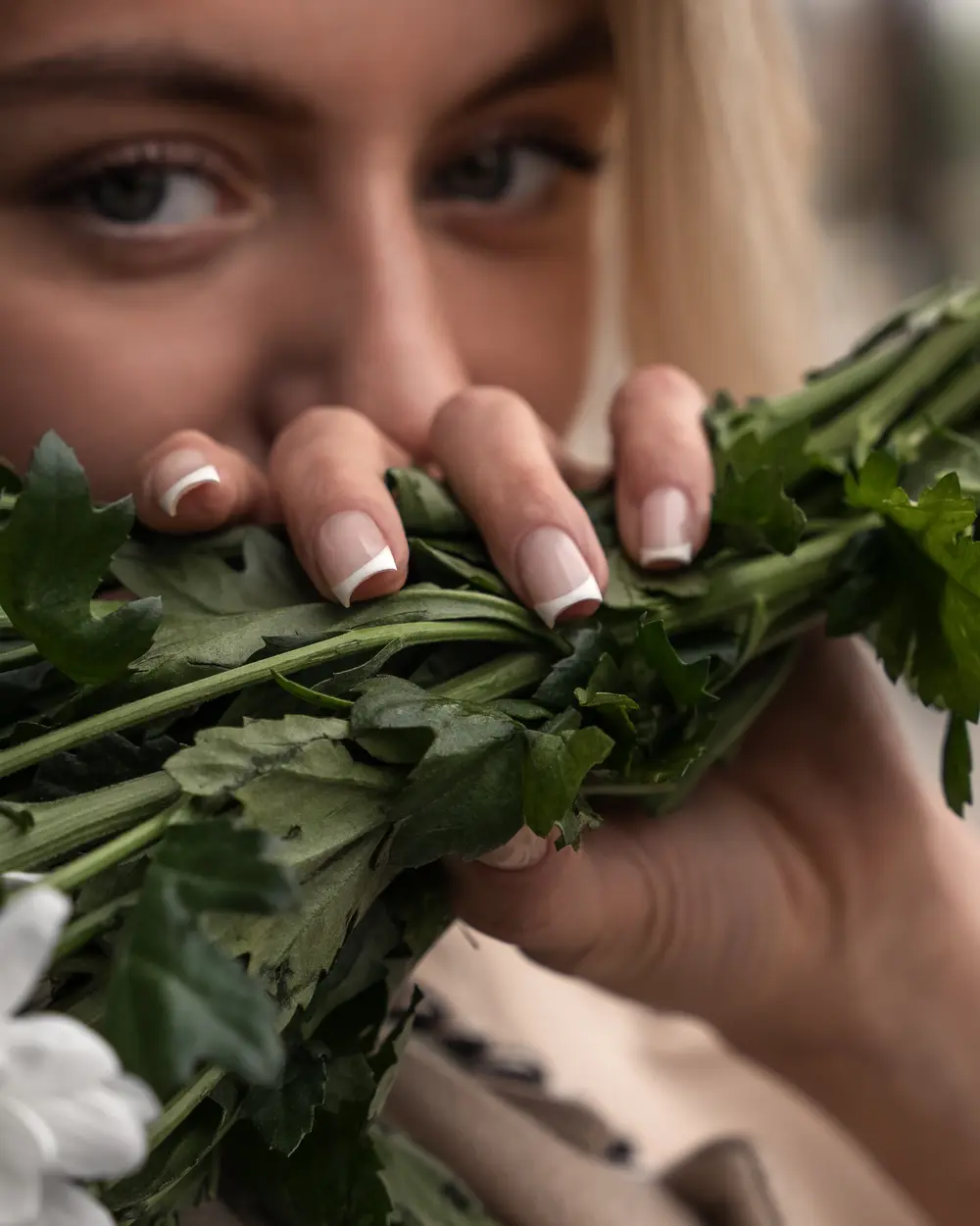 French manicure holding a bouquet of stems